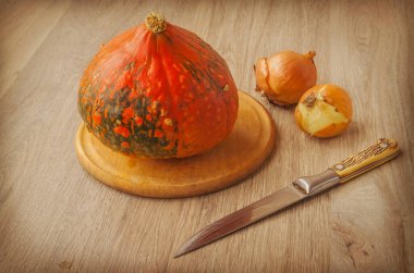 Kesme tahtasında balkabağı, mutfak masasında bıçak ve ampuller.