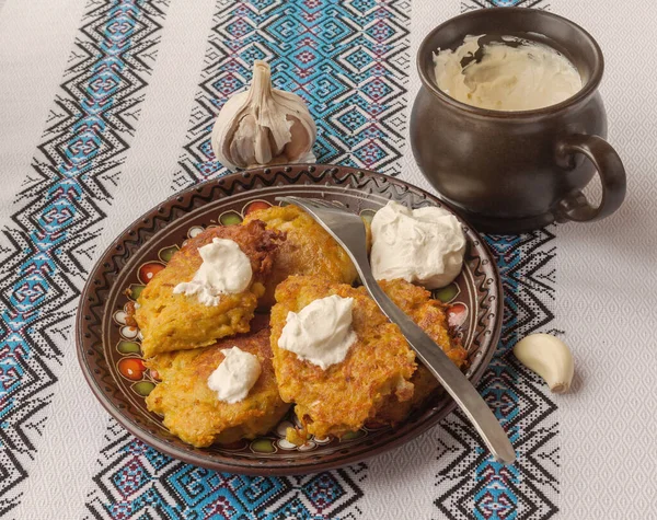 伝統的なウクライナの自家製ポテトパンケーキ サワークリームとニンジンとカボチャ — ストック写真