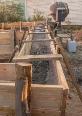 Bahçe evi inşaatı için temel oluşturan binanın yanında beton karıştırıcı var.