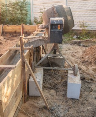 Bahçe evi inşaatı için temel oluşturan binanın yanında beton karıştırıcı var.