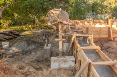 Bahçe evi inşaatı için temel oluşturan binanın yanında beton karıştırıcı var.