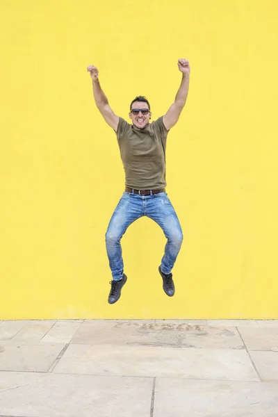 Front View Young Happy Man Wearing Sunglasses Jumping Yellow Bright — Stock Photo, Image