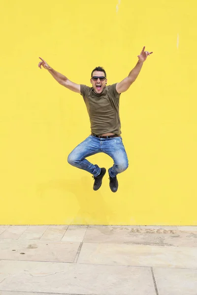 Front View Young Happy Man Wearing Sunglasses Jumping Yellow Bright — Stock Photo, Image