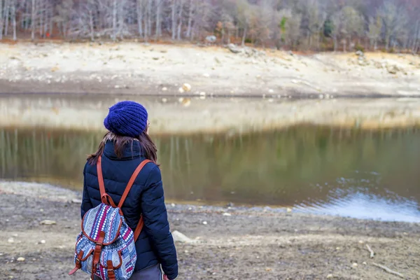 Wanderin mit Rucksack steht am See. Touristin genießt Aussicht in der Natur — Stockfoto