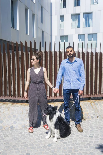 一对夫妇站在城市与狗在阳光明媚的一天 — 图库照片