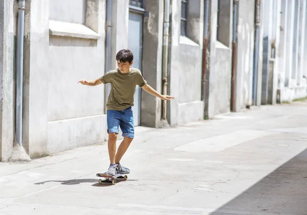 Framsidan av glada skater pojke rida på staden i en solig dag — Stockfoto