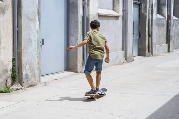 Front bild av en glad skater pojke rida på gatan i en solig dag — Stockfoto