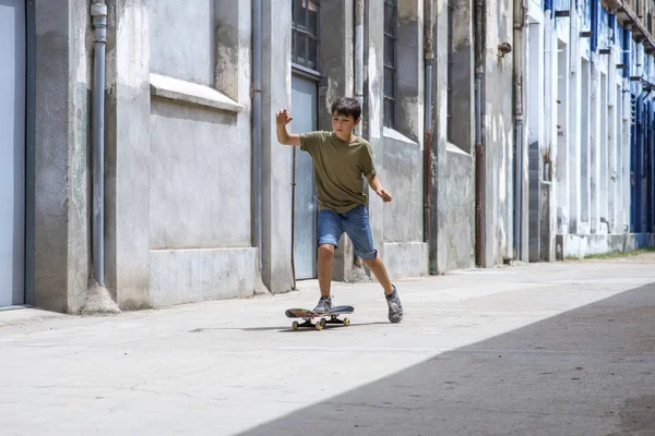 Framsidan av glada skater pojke rida på staden i en solig dag — Stockfoto