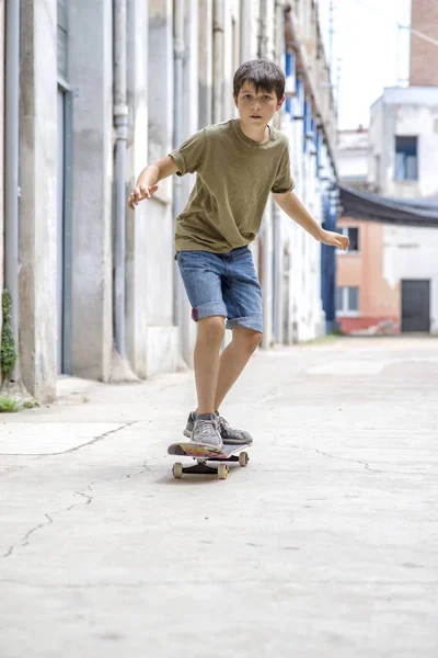 Framsidan av glada skater pojke rida på staden i en solig dag — Stockfoto