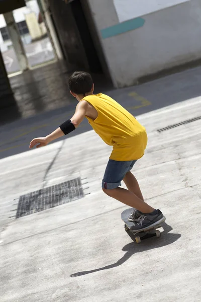 Front bild av en glad skater pojke rida på gatan i en solig dag — Stockfoto