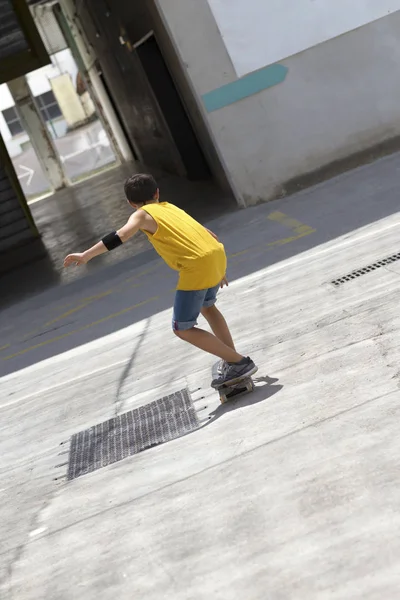 晴れた日に通りに乗る陽気なスケーター少年の正面図 — ストック写真