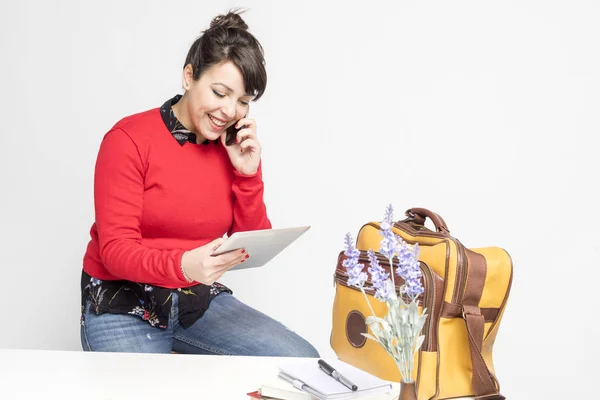 Pohled na krásnou ženu s kuličkou sedící na stoličce při telefonování a držení počítače Tablet PC proti Bílému pozadí — Stock fotografie