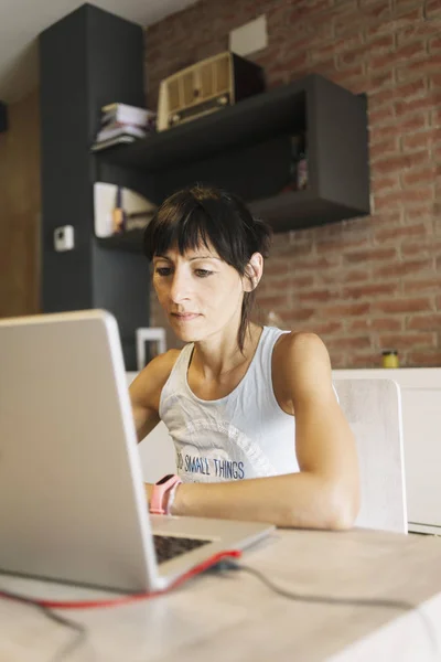 Femme avec ordinateur portable travaillant à la maison — Photo