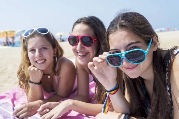 Lächeln Mädchen besten Freundinnen am Strand liegen, während Sie Kamera — Stockfoto