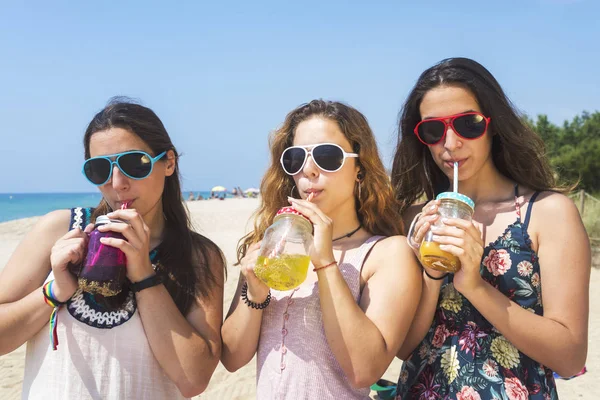 Gruppe fröhlicher junger Frauen oder Freundinnen, die am Sommerstrand auf alkoholfreie Getränke anstoßen — Stockfoto