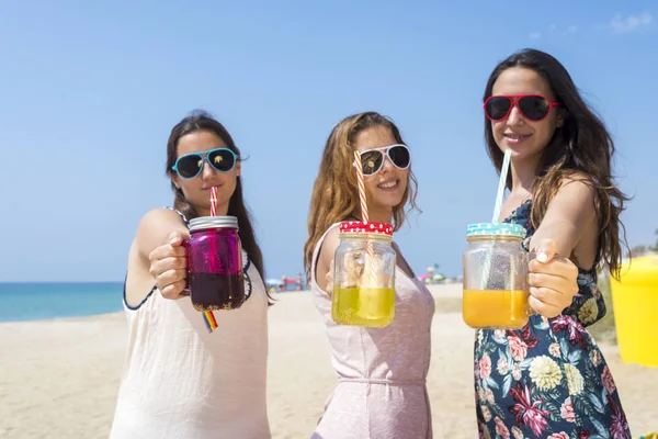 Gruppe fröhlicher junger Frauen oder Freundinnen, die am Sommerstrand auf alkoholfreie Getränke anstoßen — Stockfoto