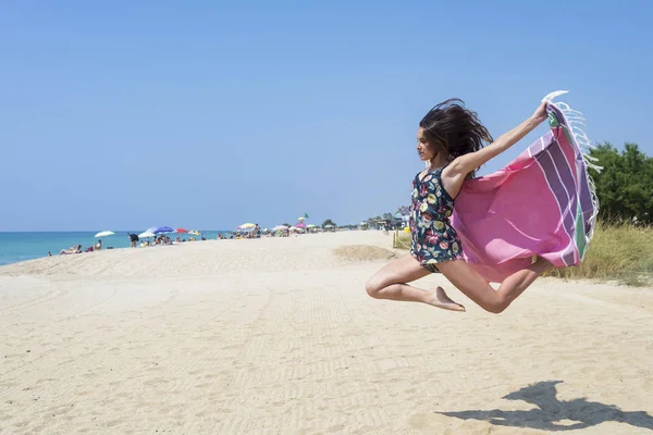 Mujer saltando con abrigo de playa —  Fotos de Stock