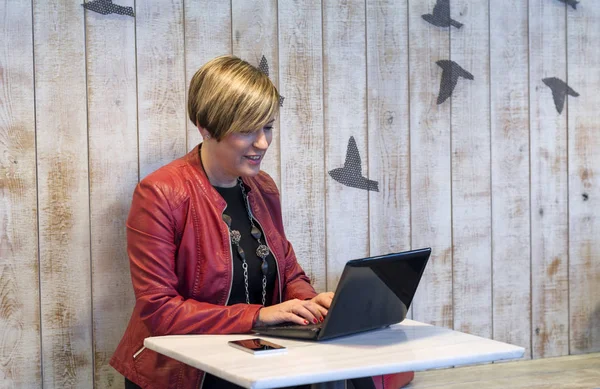 Obchodní žena používající přenosný počítač při sezení v kavárně — Stock fotografie