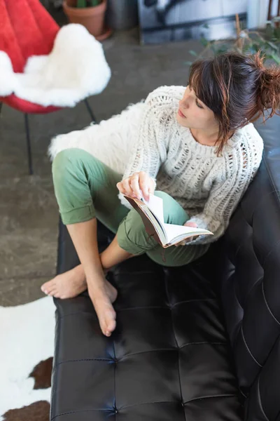 Kanepede Oturmuş Kitap Okuyan Genç Memnun Bir Kadın — Stok fotoğraf