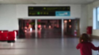 Bulanık insanlar Lizbon havaalanındaki kalkış terminalinde yürüyor