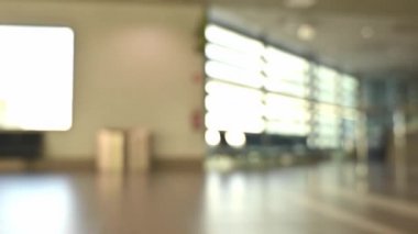Uluslararası havaalanı. İş adamları yük arabalarını çekiyor. Terminal turistleri geliyor ve lobide yürüyor.