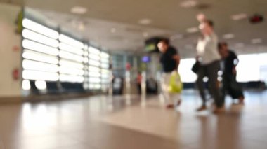 Uluslararası havaalanı. İş adamları yük arabalarını çekiyor. Terminal turistleri geliyor ve lobide yürüyor.