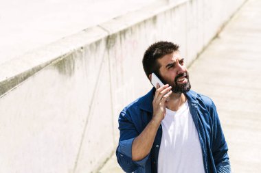 Cep telefonunu kullanan sakallı bir adamın portresi..