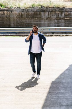 Cep telefonunu kullanan sakallı bir adamın portresi..