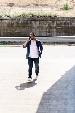 Cep telefonunu kullanan sakallı bir adamın portresi..