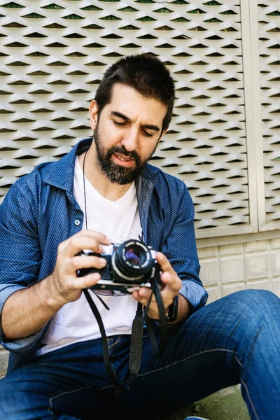 Vrolijke Bebaarde Reiziger Die Grond Zit Terwijl Hij Een Camera — Stockfoto