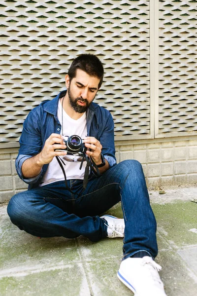 Veselý Vousatý Cestovatel Muž Sedí Zemi Při Kontrole Fotoaparátu — Stock fotografie