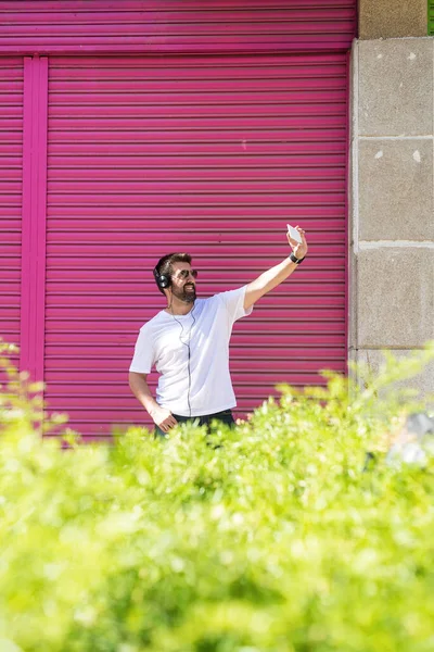 髭を生やした男とともにサングラス取ります自画撮りにピンクの壁 — ストック写真