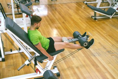 Genç sporcu ağırlıkla bacak genişletme yaparken neredeyse bağırıyordu.