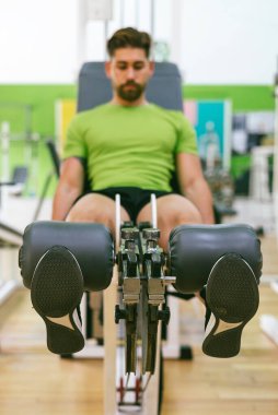 Genç sporcu ağırlıkla bacak genişletme yaparken neredeyse bağırıyordu.