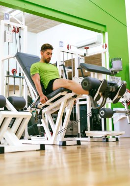 Genç sporcu ağırlıkla bacak genişletme yaparken neredeyse bağırıyordu.