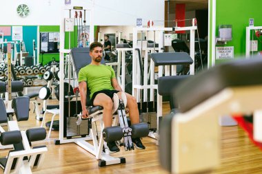 Genç sporcu ağırlıkla bacak genişletme yaparken neredeyse bağırıyordu.