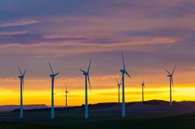 Rüzgar türbinleri gün batımına karşı sahada İspanya 'da