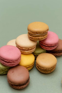 Yeşil arka planda çeşitli renkte badem kurabiyeleri..