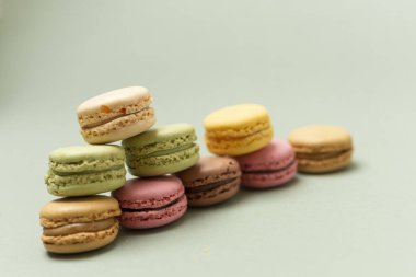 Yeşil bir zemin üzerinde renkli, lezzetli kurabiyeler yığını..