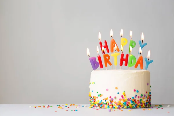 Bolo de aniversário com velas coloridas — Fotografia de Stock
