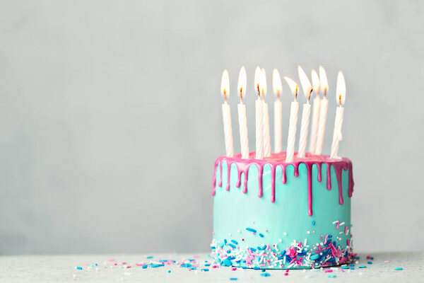 Торт на день рождения с голубой глазурью, розовой глазурью и десятью белыми свечами на день рождения