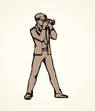 Genç kameraman adam beyaz zemin üzerinde anlık görüntü oturum yapmak. Anahat siyah mürekkep elle çizilmiş slr lens simgesini işaret yarım yamalak retro sanatsal doodle karikatür tarzı tükenmez kalemle kağıt alanı metin için resim