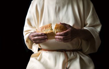 Lezzetli taze, beyaz, yuvarlak arpa taneli çörek ekmeği aç kız çocuğunun çalışmasına yardımcı olur. Kapalı eski erkek tanrı İsa kol inancı sıcak kabuklu çavdar diyeti mutfağı retro İncil karanlık ev metni alanı