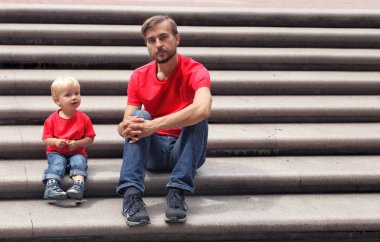 Baba ve yürümeye başlayan çocuk oğlu merdivenlerde. Aile giyim bak. Kopya alanı.