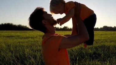 Günbatımı baba oyunundan yürümeye başlayan çocuk oğluyla. Canlı kamera, ağır çekim.