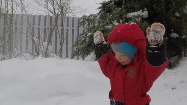 可爱的小男孩在冬季西装举起他的手 雪飞走了 反转慢动作超级英雄 或心灵遥感概念 — 图库视频影像