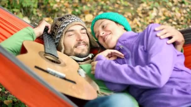 Gelukkige Paar Koelen Hangmat Herfst Bos Kussen Lachen Praten Gitaar — Stockvideo