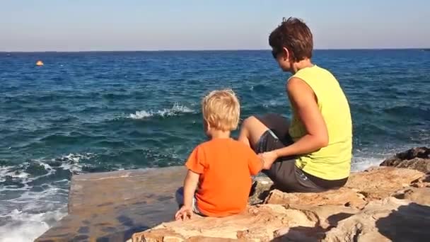 Short Haired Mother Her Toddler Son Sitting Edge Rocky Seashore — Stock Video