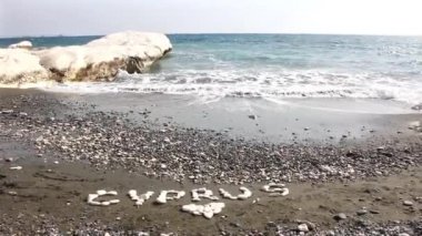 Siyah kum ve beyaz kayalar ile ünlü Vali plaj. Yazıt Kıbrıs'tan su kenarındaki taş. 