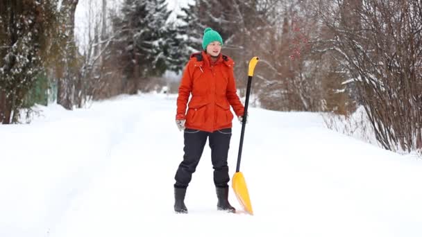 女性は 誰が彼女を見て ギターのようなシャベルに遊びだす雪のシャベルと道路をクリーンアップします 冬の楽しみの概念 — ストック動画